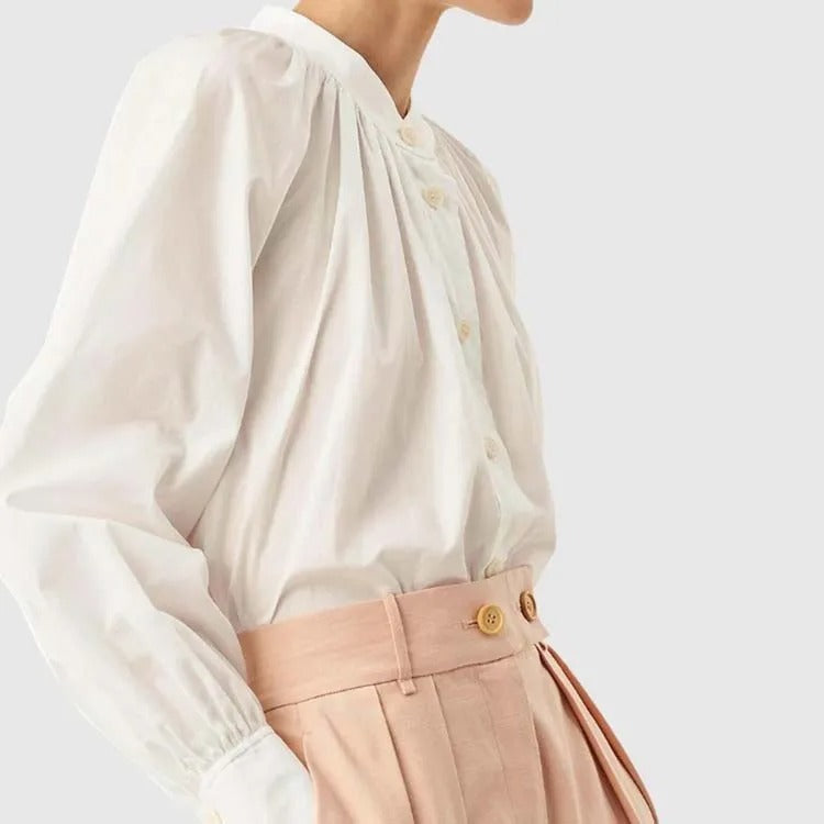 iała bluzka zapinana na guziki z marszczonym dekoltem