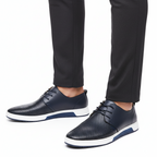 Men's perforated lace up derby shoes in blue, worn with tailored trousers